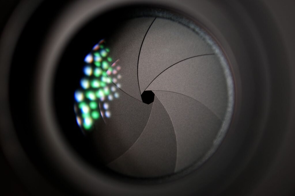 Close view inside a camera lens showing curved aperture blades closed to a small opening
