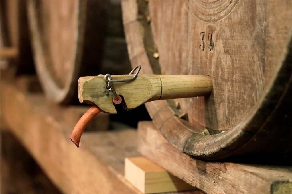 Carved wooden spigot fitted into the head of a barrel resting on a timber rack