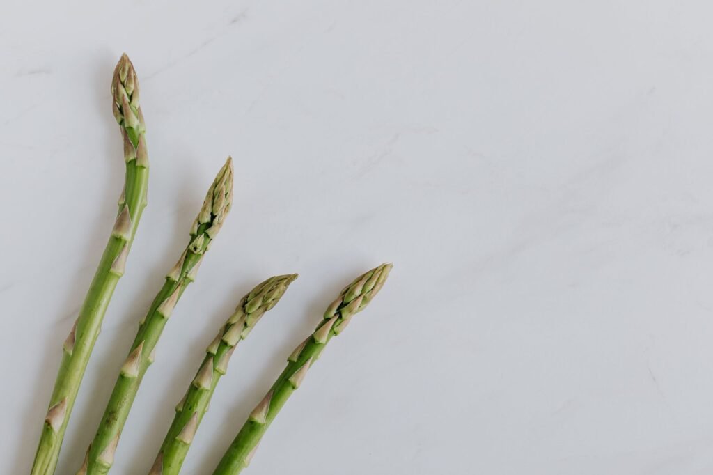 Top view of fresh green asparagus stalks on minimalist white background.