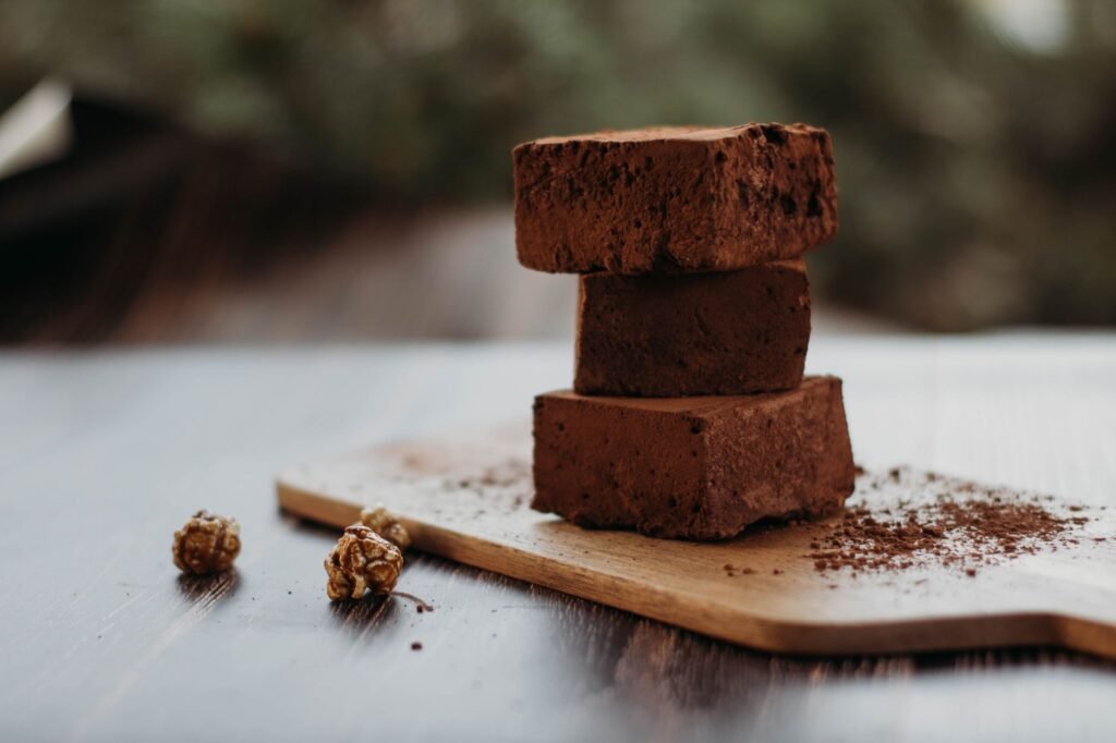Close-up of rich chocolate brownies stacked on a wooden board, perfect for dessert lovers