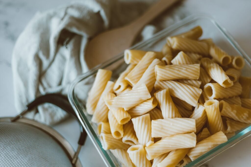 Delicious rigatoni pasta cooked to perfection, presented in a glass dish for a tasteful food display.