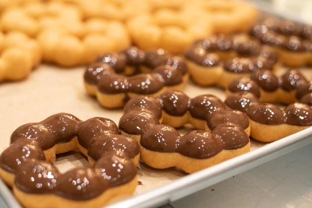 Freshly baked chocolate glazed mochi donuts on a tray in a San Francisco bakery