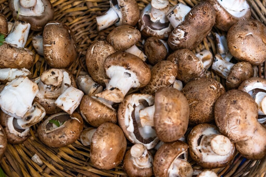 A close-up of fresh brown mushrooms in a woven basket, showcasing earthy textures.