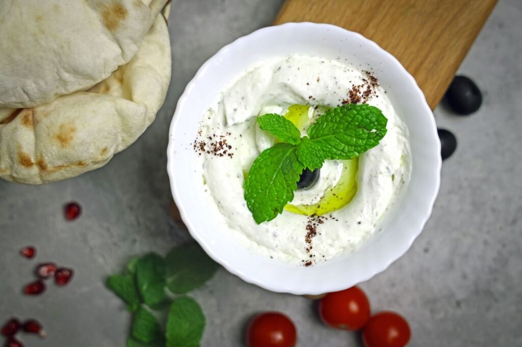 Creamy Greek yogurt dip garnished with mint and olive, perfect for a healthy snack.