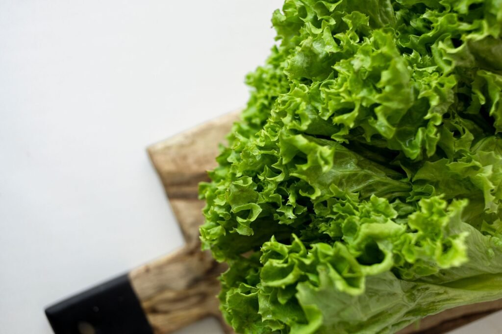 Close-up of fresh green lettuce leaves on a rustic wooden cutting board