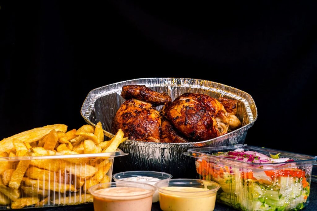 Appetizing rotisserie chicken with french fries and salad, a perfect meal.