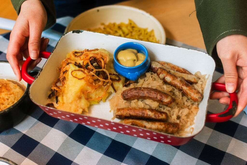 A rustic platter with sausages, sauerkraut, mustard, and mashed potatoes, perfect for hearty meals