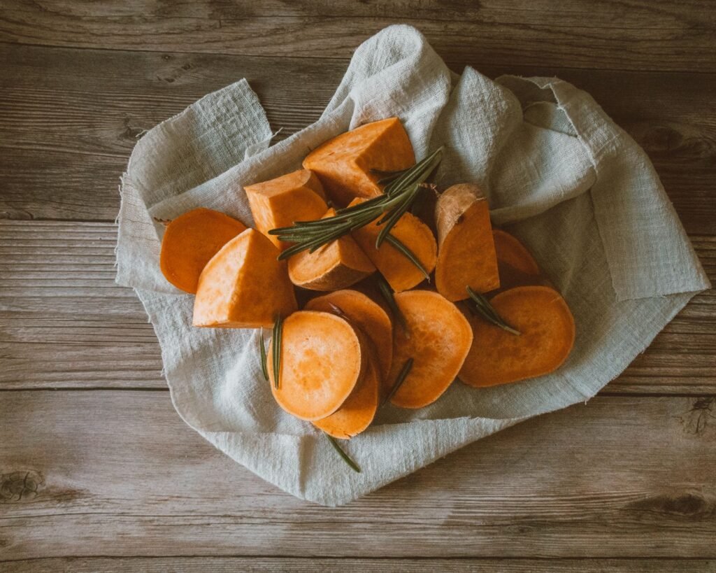 A rustic setting with sliced sweet potatoes on a wooden surface, perfect for fall recipes