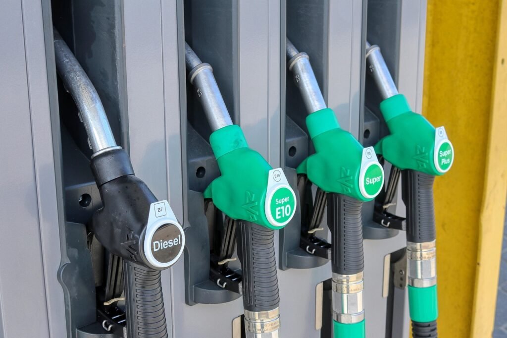Row of fuel pump nozzles hanging at a station, including a black diesel nozzle