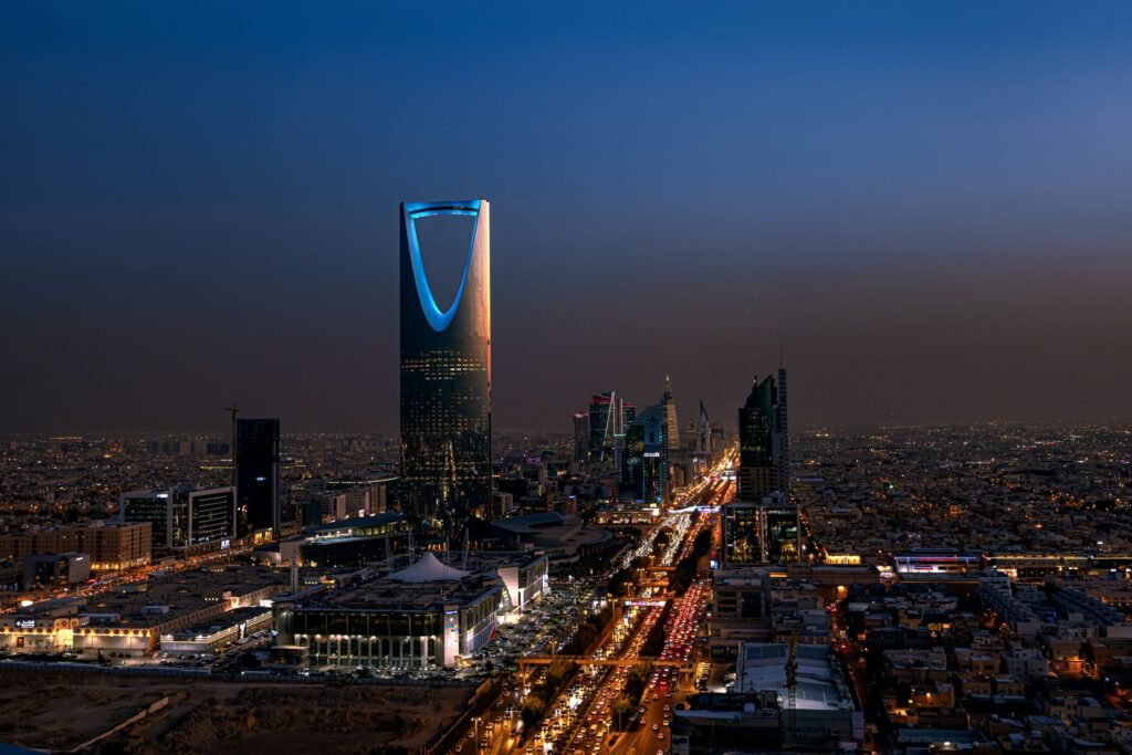 A breathtaking aerial view of Riyadh at night featuring the iconic Kingdom Centre Tower