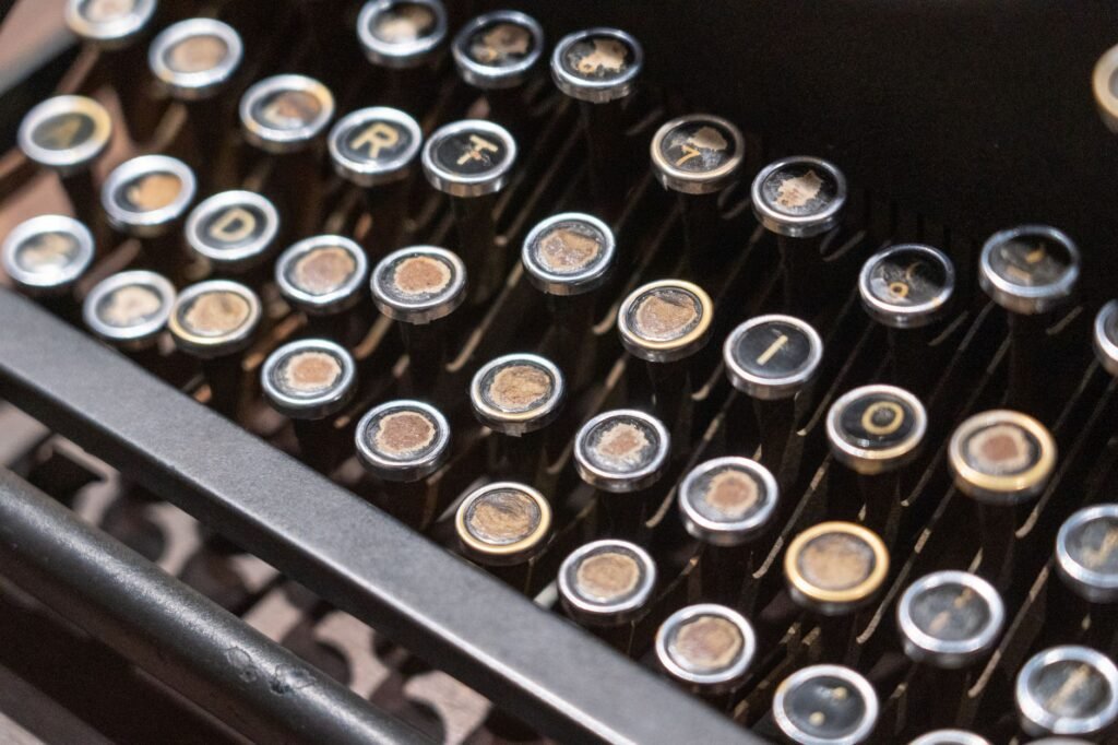 Close view of round vintage typewriter keys with worn letters on a dark metal frame