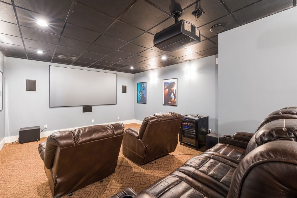 Ceiling mounted projector aimed at a screen in a home theatre room