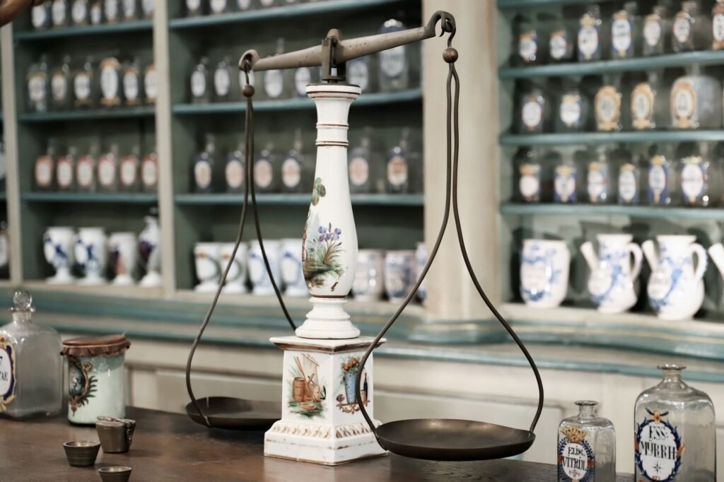 Close-up of antique scales and medicine bottles in a vintage pharmacy setting
