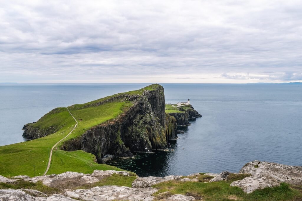 A lighthouse on a headland seen from far out at sea