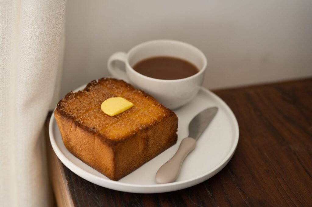 A cozy breakfast setting featuring toasted bread with butter and a cup of coffee on a wooden table