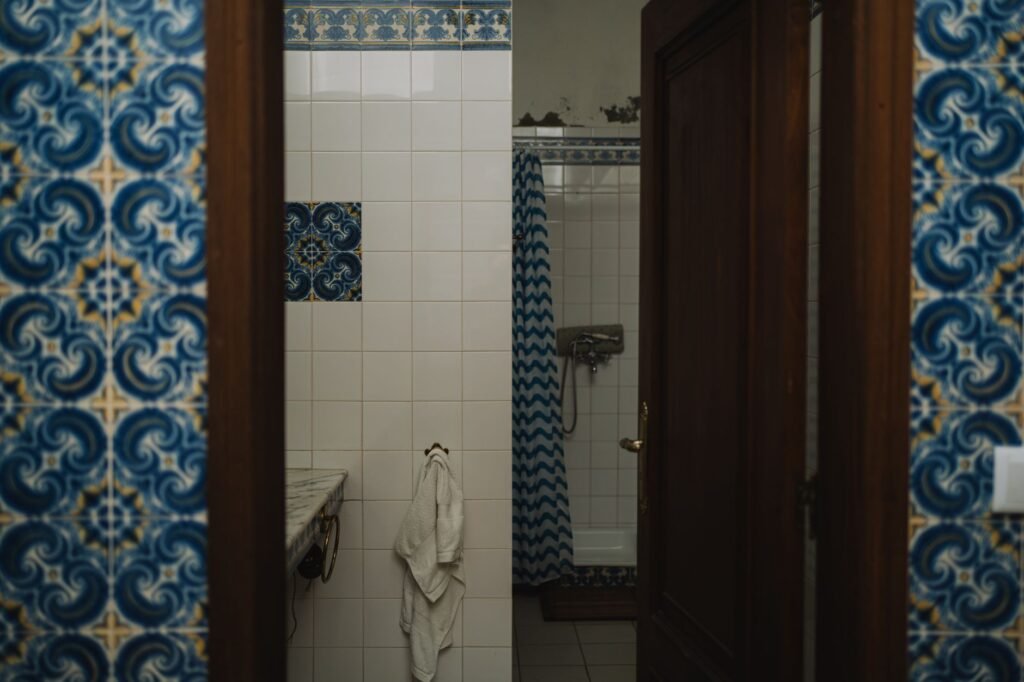 Bathroom with vintage blue tile design and shower, offering a classic feel