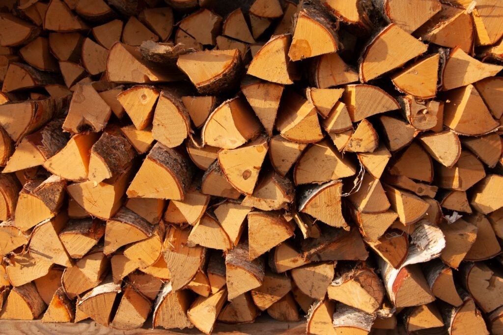 Tightly stacked split firewood logs showing pale cut ends and bark edges
