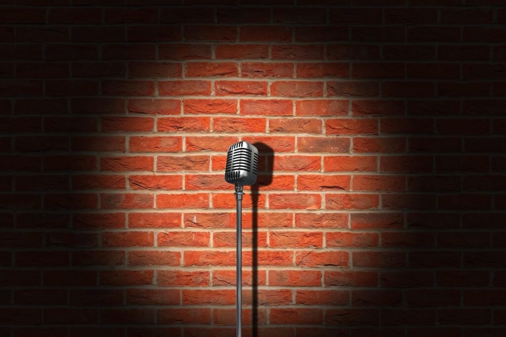 A microphone on a stand under a spotlight on a club stage