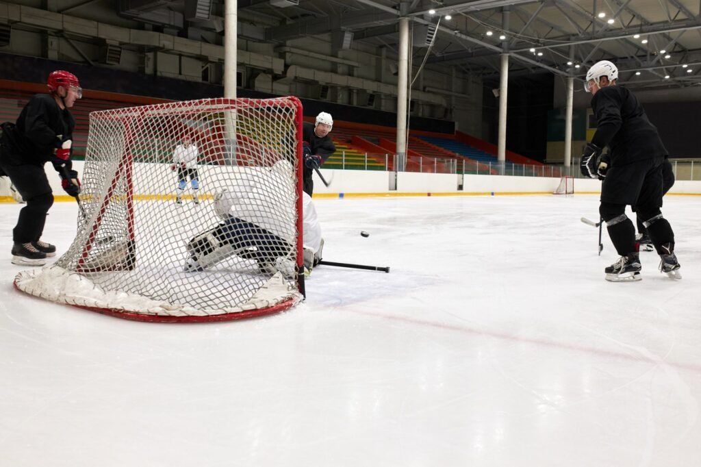 Competitive ice hockey players in action during a practice match inside an indoor rink