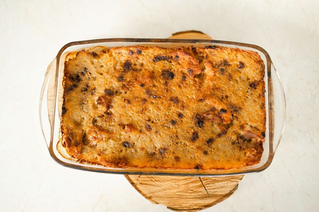 Top view of a freshly baked casserole in a glass dish on a wooden board
