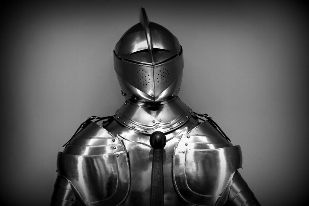 Polished steel suit of armor with a closed visor helmet against a dark gray backdrop