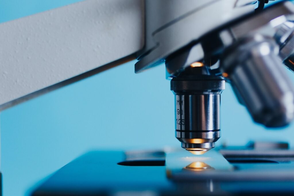 Close view of a microscope objective lens lit above a glass slide