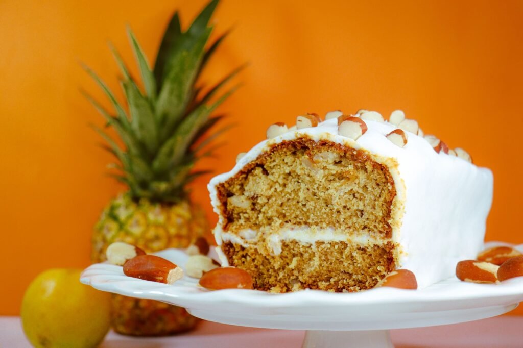Close-up of a frosted pineapple almond cake on a stand, perfect for dessert lovers