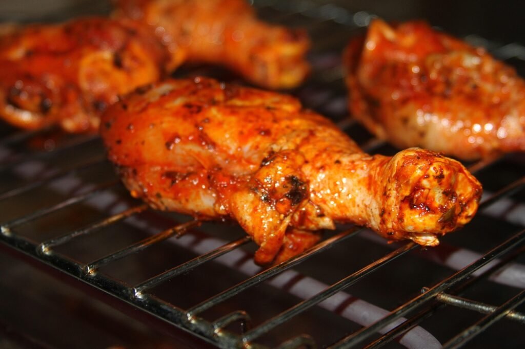 Seasoned chicken leg quarters roasting on a wire oven rack