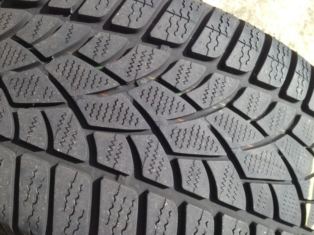 Close view of tire tread blocks with deep grooves and thin zigzag sipes