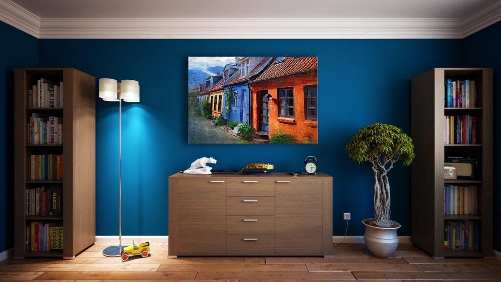 Living room with a deep blue painted wall, bookcases, a floor lamp and a wooden dresser