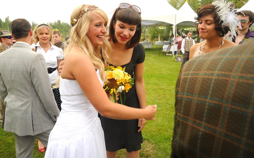 Mrs. Jessie Morse, wearing her white wedding dress, next to her groom Chris, smiling holding a bouquet and ...