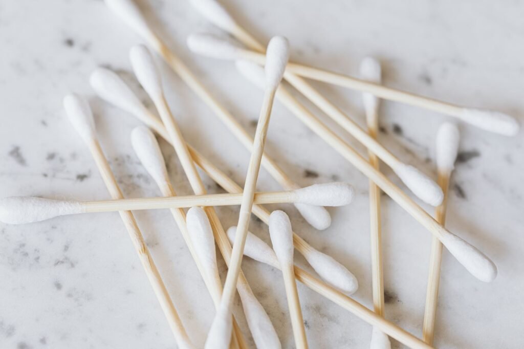 Scattered cotton swabs with wooden sticks on a white marble surface
