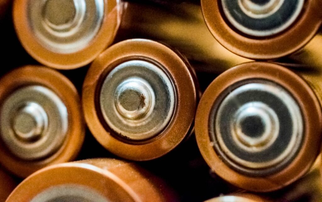 Close view of the metal ends of several copper topped AA batteries