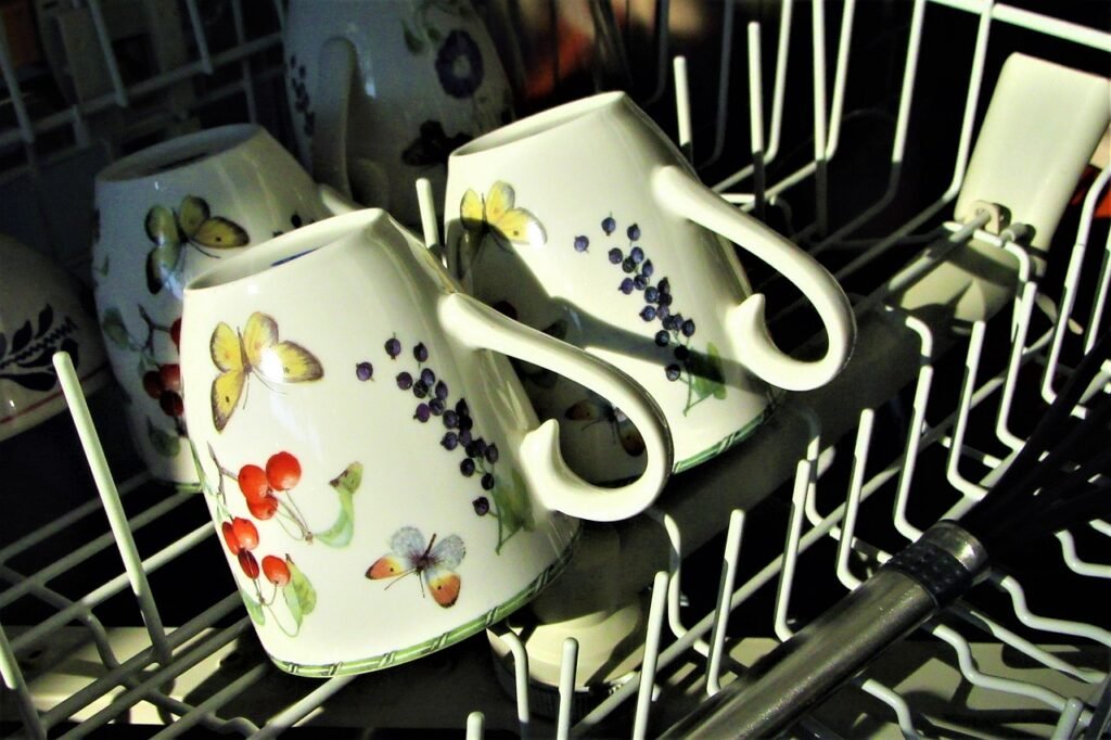 Patterned coffee mugs turned upside down in a dishwasher rack