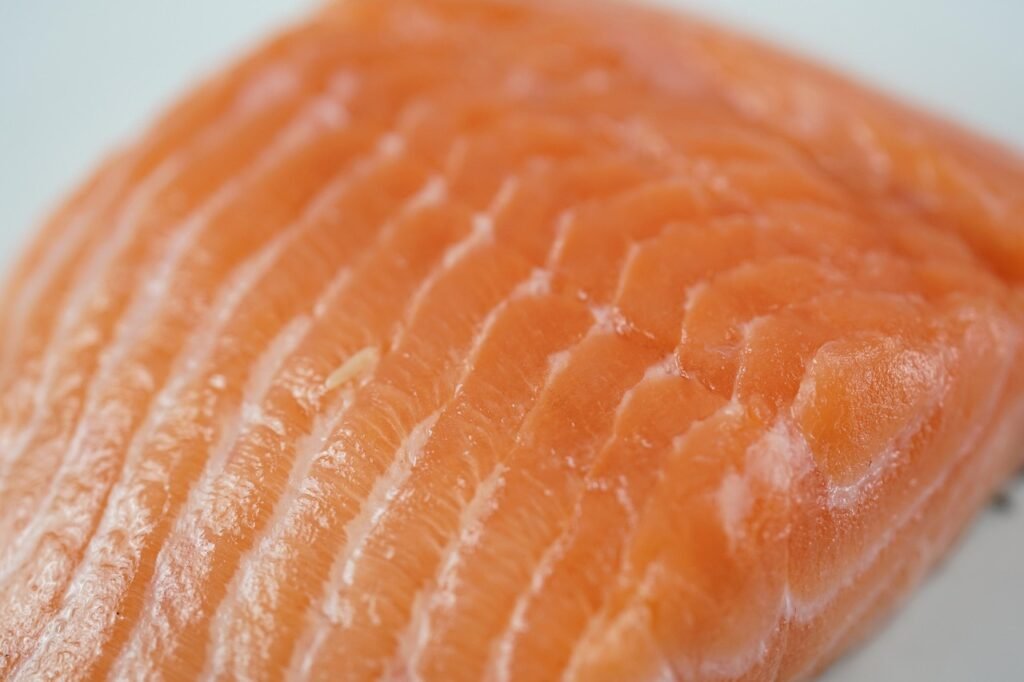 Close view of a raw salmon fillet showing its orange flesh and white lines