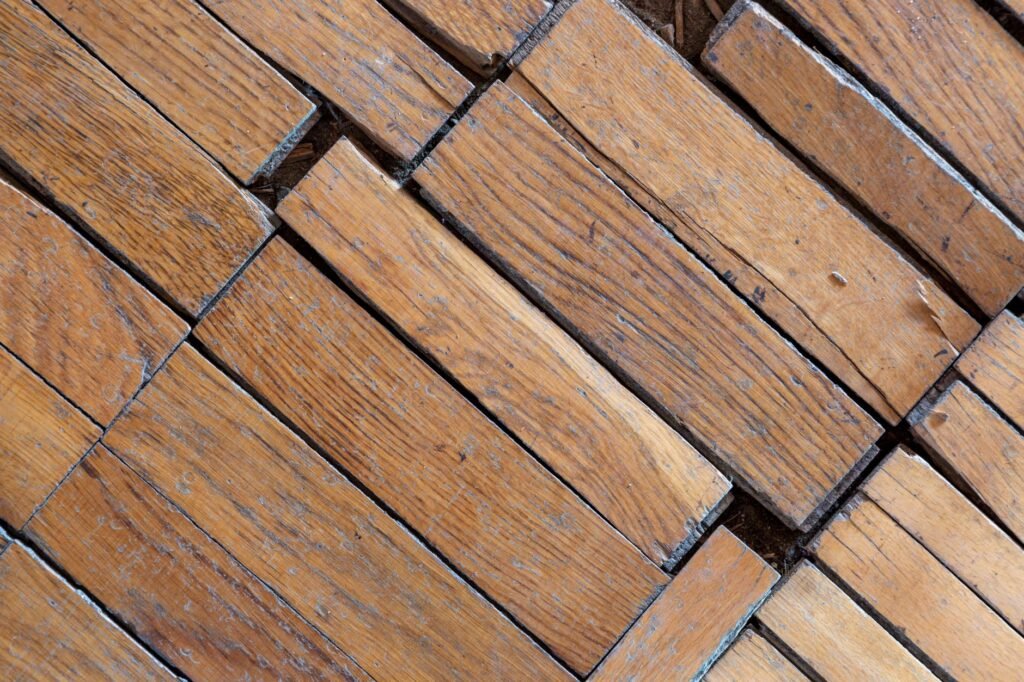 Close view of worn wooden floorboards with visible gaps between the loose planks