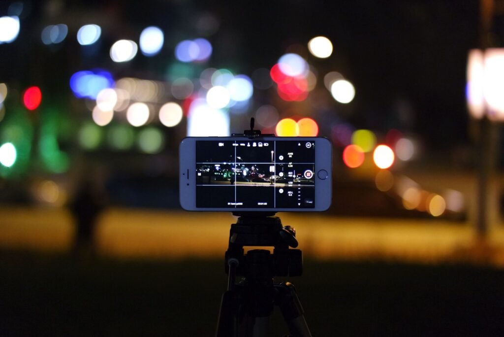 Smartphone mounted on a tripod filming a night scene full of blurred colorful lights