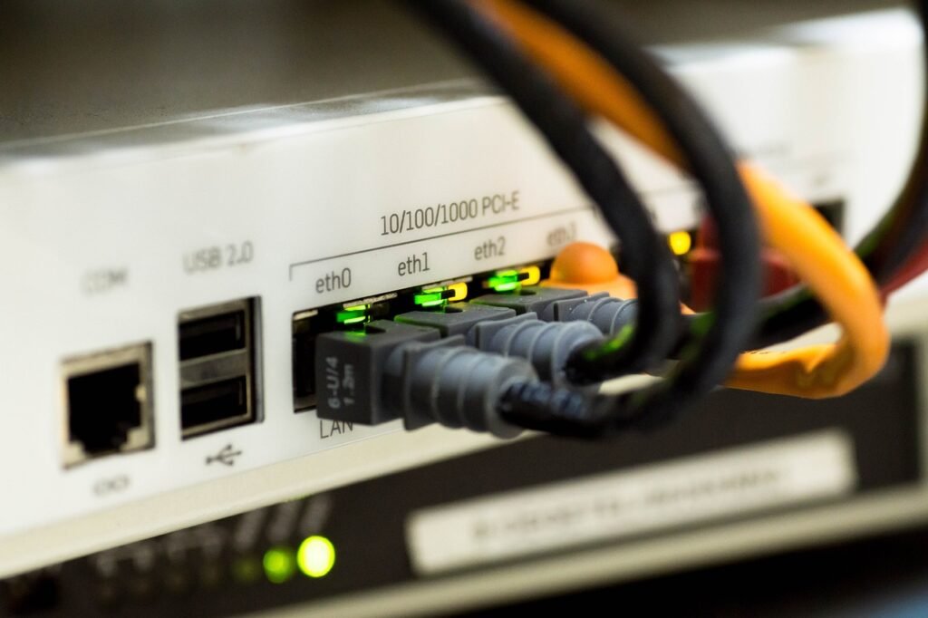 Back of a network router with ethernet cables plugged into its ports and green status lights