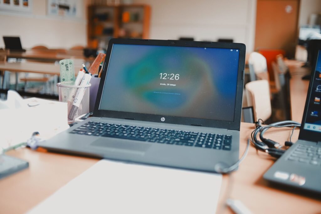 Open laptop on a desk showing a lock screen clock in a bright room