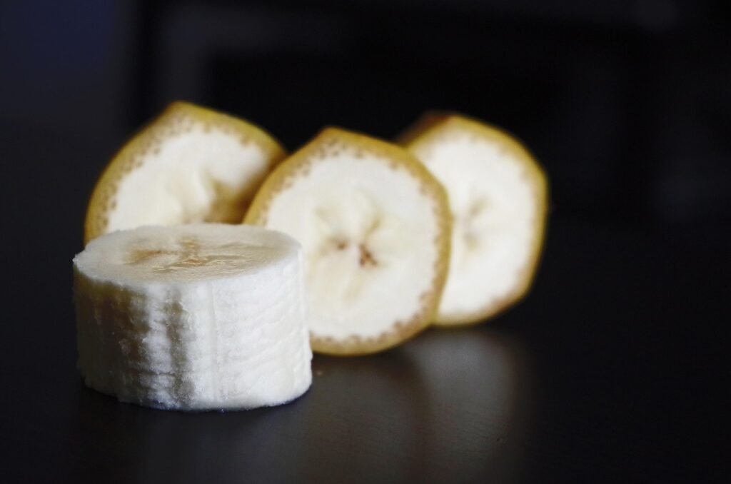 Thick slices of peeled banana on a dark background