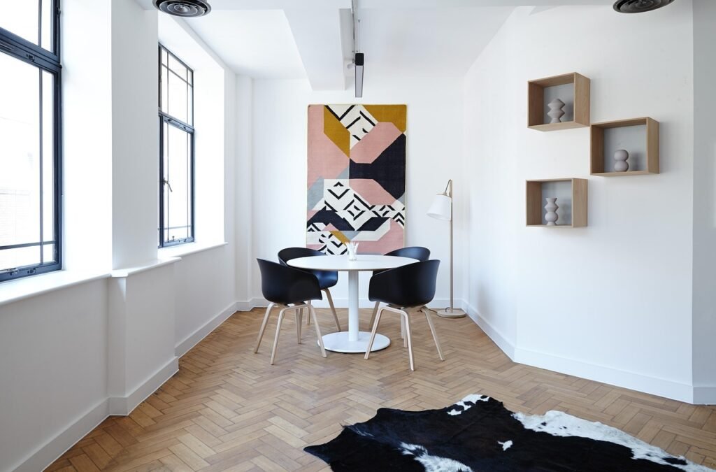 Bright white dining room with three wooden box shelves mounted on the wall beside a round table