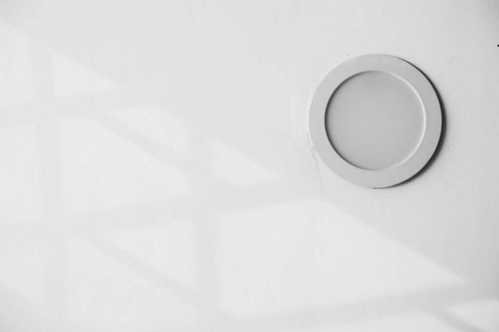Round recessed light fixture set flush into a white ceiling