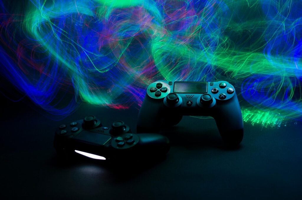 Two black game controllers on a dark surface under swirling green and blue light trails