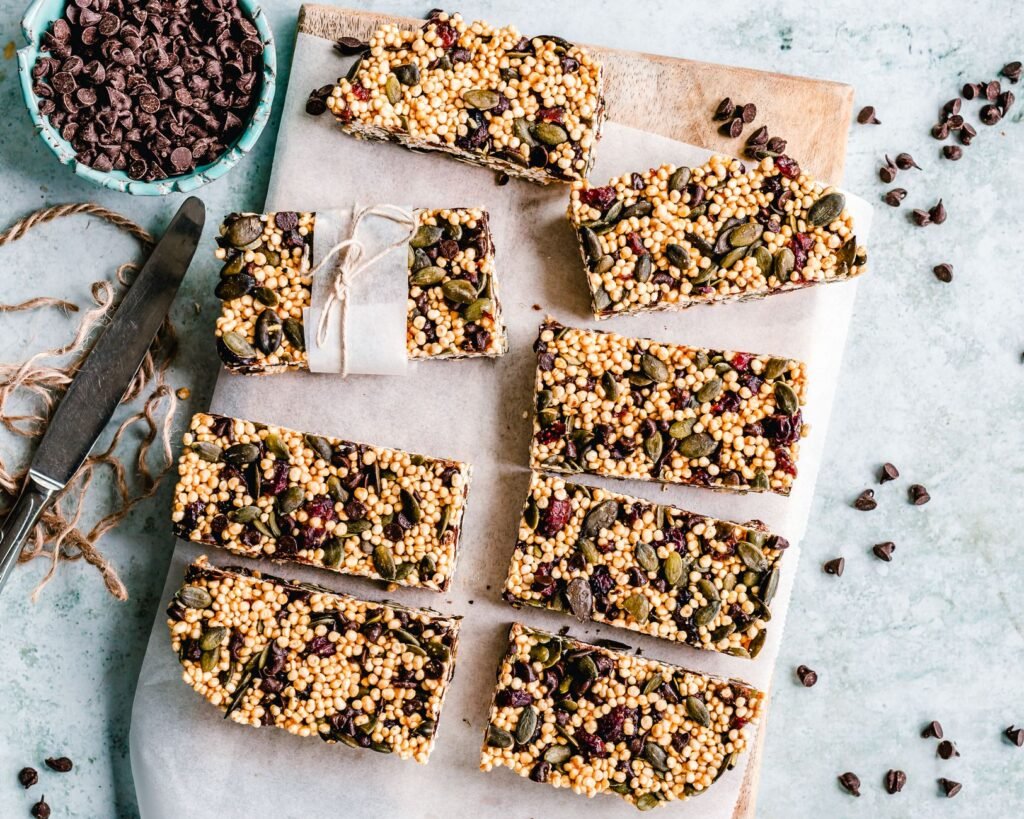 Homemade granola bars with dried fruit cut into rectangles on parchment paper