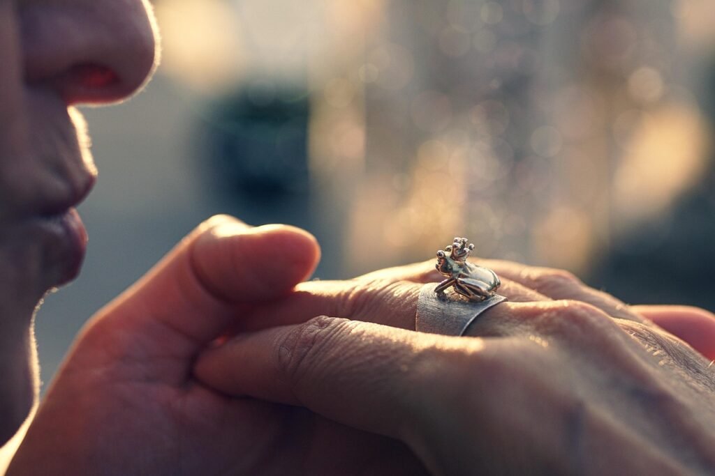 Close up of a hand wearing a small silver ring in warm soft light