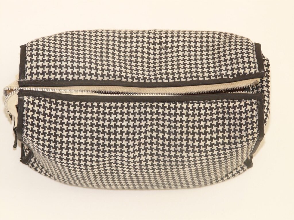Black and white patterned zippered toiletry pouch on a cream background
