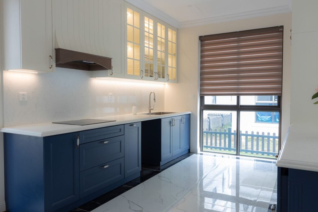 Kitchen with navy blue painted lower cabinets, white upper cabinets and a white countertop