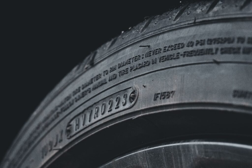 Detailed close-up image of a black car tire showcasing sidewall text and treads