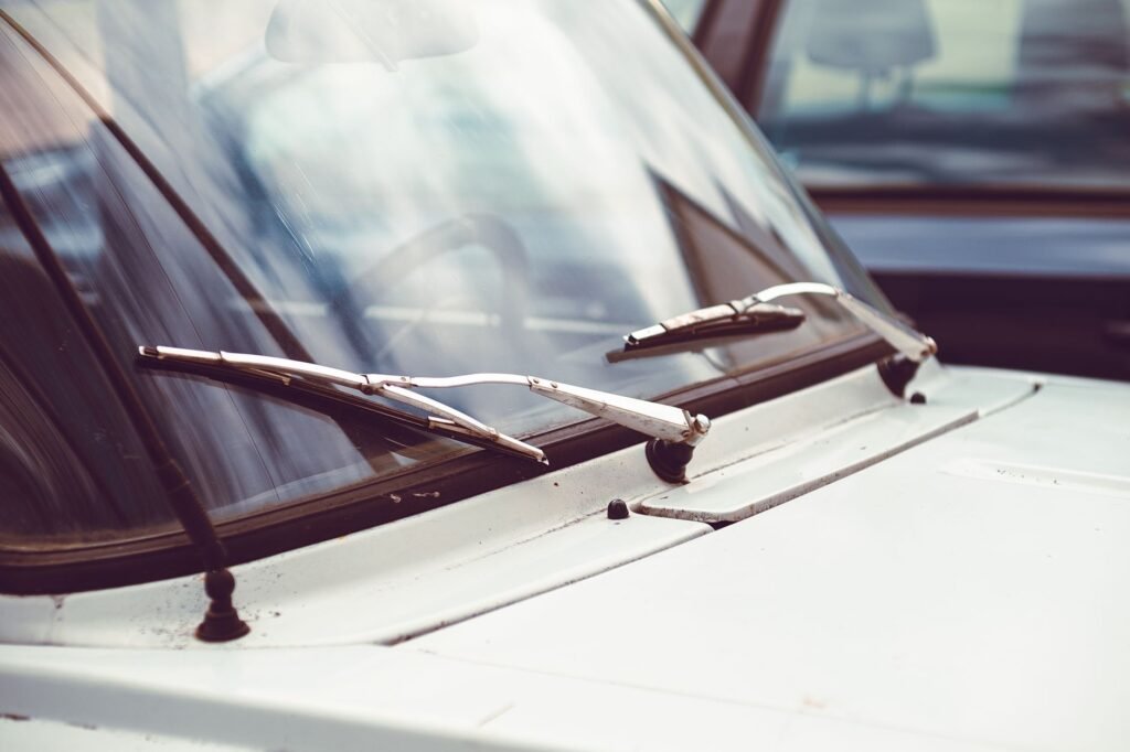 Windshield wiper blades resting on the glass of a white car