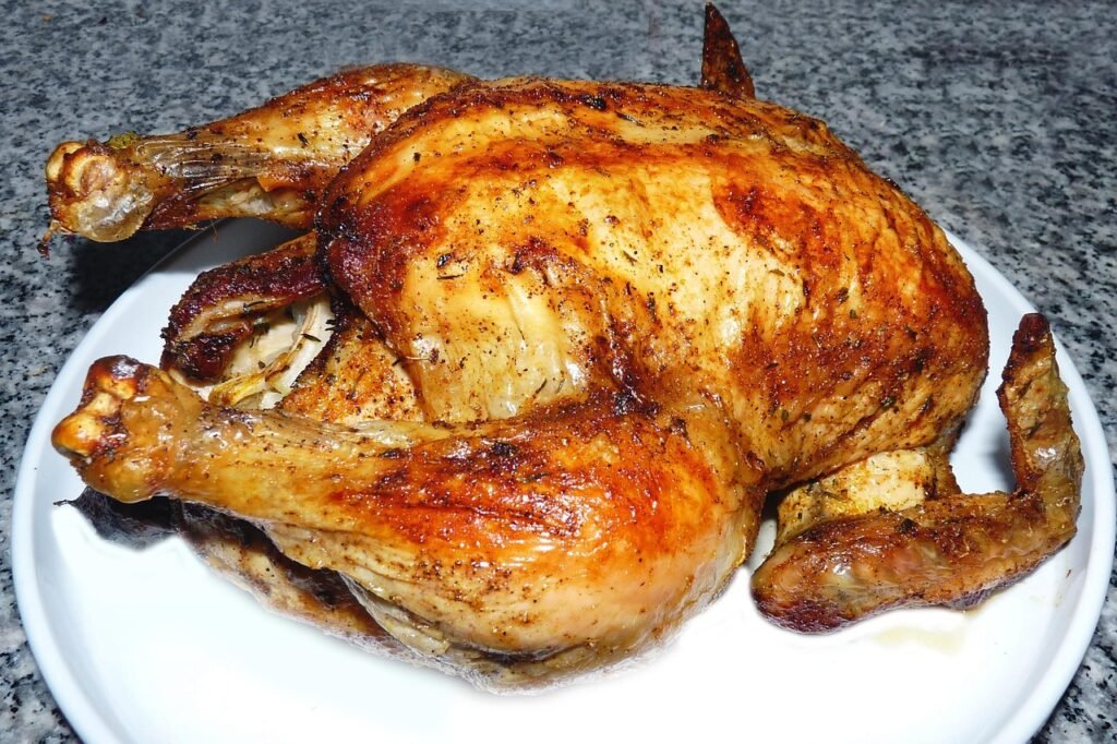 Golden roast chicken with crispy skin on a white plate
